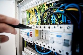 Dix erreurs dangereuses à éviter en rénovation électrique Électricien contrôlant un tableau électrique pendant une rénovation